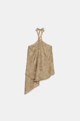 Top de cuello halter con tiras cruzadas para atar al cuello, hombros descubiertos y bajo asimétrico con caída drapeada y textura rústica con estampado sutil.