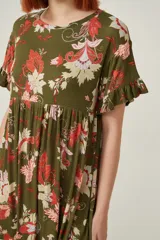 Vestido corto de viscosa con estampado floral en tonos verdes, rojos y blancos. Presenta un diseño holgado con cuello a la base y mangas cortas con volados en los extremos.