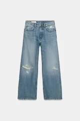 Jeans de corte boyfriend y tiro medio, con diseño de cinco bolsillos, cierre frontal con cremallera y botón metálico. Presenta un acabado lavado con detalles de roturas y desgastes.
