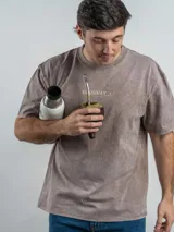 Remera de corte oversize color marrón con efecto lavado, cuello redondo y estampa frontal con la frase 'URUGUAY noma!'.