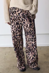Jeans de tiro medio con diseño de cinco bolsillos, cierre frontal con cremallera y botón, y cintura con trabillas. Presenta un corte recto y largo completo con estampado animal print.