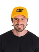 Gorro tipo gorra Caterpillar de color amarillo, con visera curvada y el logotipo de la marca bordado en color negro en la parte delantera.