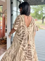 Vestido largo de corte amplio con estampado floral en tonos turquesa, blanco y rosa. Posee escote en V, mangas cortas y espalda con lazo.