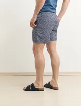 Short de baño azul con estampado geométrico en blanco y negro.