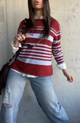 Sweater fluido de punto con diseño de rayas horizontales en color bordó y celeste, de manga larga y cuello redondo.