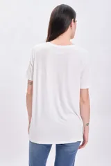 Remera de manga corta con cuello redondo a la base, de corte clásico y color crudo.