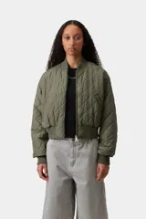 Campera matelaseada de color verde militar, con diseño acolchado en forma de rombos, cuello, puños y dobladillo en punto acanalado, cierre frontal completo y corte estilo bomber.
