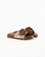 Sandalias de cuero color negro, de diseño plano con una tira ancha en el empeine y una hebilla metálica dorada grande como detalle.