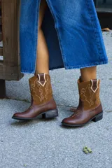 Botas tejanas de cuero vacuno color marrón con apliques de gamuza color camel y bordados en hilo blanco.