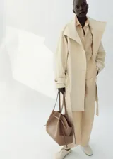 Pantalón de lino color beige, de diseño recto y largo con tiro medio, dos bolsillos laterales y cintura ajustable.
