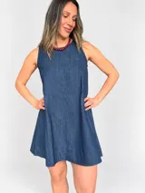 Vestido corto de denim azul sin mangas, con corte evasé amplio y fluido.