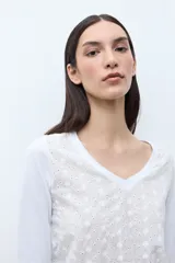 Remera de manga tres cuartos con escote en V, confeccionada en tela con textura de broderie en el frente.