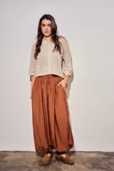 Babucha de viscosa color ladrillo, de tiro alto con cintura elástica fruncida y cordón ajustable del mismo tejido, con diseño fluido y puños ajustados en los tobillos.