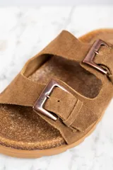 Sandalias marrones de cuero gamuzado con doble tira y hebillas metálicas.