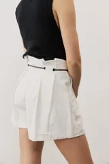Short blanco de tiro alto, confeccionado en lino, con bolsillos laterales y cordón ajustable en la cintura.