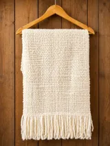 Pashmina tejida a mano de 100% lana merino color beige, con diseño texturizado y flecos en los extremos.
