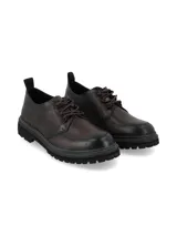 Zapato acordonado de cuero con acabado envejecido, diseño de puntera reforzada y suela track dentada con costura decorativa en contraste.