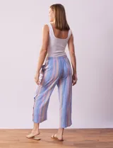 Pantalón de algodón estampado a rayas verticales azules y blancas, marca Erika. Tiene pretina elastizada, bolsillos delanteros, ruedo lateral con tajo y botones decorativos.