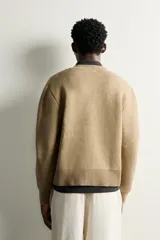 Cardigan de punto relaxed fit de color tostado, con cuello redondo y manga larga. Presenta acabados en rib y cierre frontal de botonadura.