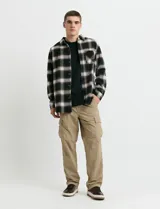 Sobrecamisa de manga larga con diseño a cuadros, cuello camisero y bolsillo frontal. Confeccionada en tejido de poliéster y algodón, sin forro.