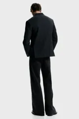 Blazer de botonadura sencilla con solapas de muesca, cierre de dos botones y abertura doble trasera. Presenta un diseño a rayas finas, bolsillo superior, bolsillos delanteros con solapa y botones decorativos en los puños. Cuenta con forro interior y dos bolsillos internos.