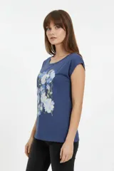 Remera de algodón blanca de manga corta, con cuello redondo y estampado frontal con la leyenda "New York" y flores abstractas en tonos marrones y rosados.