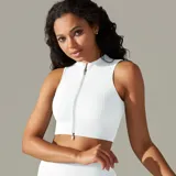 Top deportivo blanco de punto acanalado, con cuello alto y cierre frontal con cremallera.