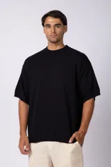 Remera de punto color crema, de manga corta, con cuello redondo acanalado y corte oversize.