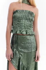 Top strapless de tela metálica con textura plisada, corte ajustado al cuerpo y diseño corto. Incluye una gargantilla a juego del mismo material.