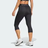 Calza capri deportiva Adidas Techfit de color negro, con diseño de compresión y tiro alto. Presenta una cintura elástica ancha con la inscripción "TECHFIT" repetida y el logo de la marca en blanco en la pierna izquierda.