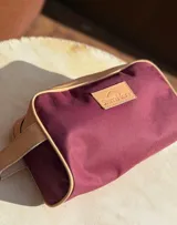 Neceser de lona verde con detalles en cuero color beige y etiqueta con logo de la marca Sierra Mora.