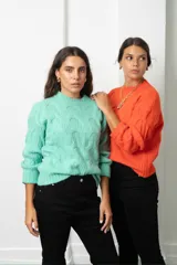 Buzo de tejido de punto con diseño de ochos, cuello redondo y mangas largas con puños acanalados.