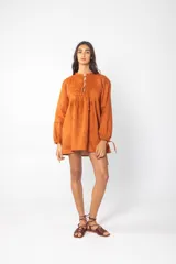 Vestido corto color naranja, de corte holgado y manga larga con lazos en los puños.