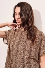 Blusa color beige con estampado animal print en marrón, de corte holgado y mangas cortas.