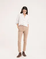 Pantalón chupín color beige de gabardina elastizada con tajitos frontales en el ruedo, pierna recta justa y bolsillos laterales.
