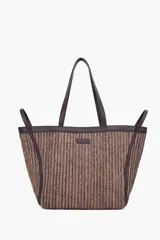 Bolso tipo tote confeccionado en rafia con textura rayada en tonos beige y marrón, con asas largas y detalles en cuero sintético marrón. Incluye placa con el logo de la marca en el frente.