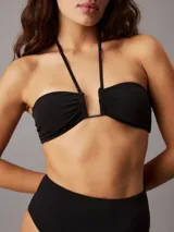 Corpiño de bikini bandeau negro con tirantes finos y detalle metálico en el centro.