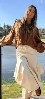 Camisa de manga larga con volumen y puños elásticos, de color marrón oscuro.