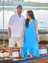 Vestido de lino sin mangas en color turquesa, con escote en V y detalle de volado en el ruedo con terminación asimétrica.