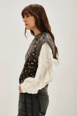 Chaleco de punto con diseño de animal print de leopardo en tonos grises y negros, con cuello redondo y corte sin mangas.