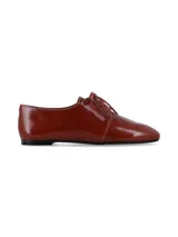 Zapato tipo oxford de cuero charolado color suela, con cierre de cordones al tono y suela plana.