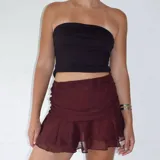 Minifalda marrón de tul con frunces laterales y volados en el ruedo.