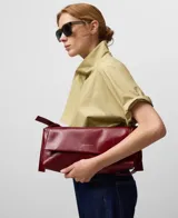 Bolso de hombro Adolfo Domínguez modelo Orión, confeccionado en piel de búfalo con acabado craquelado brillante. Presenta un diseño rectangular con solapa, cierre magnético y asa corta regulable con hebilla.