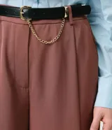 Pantalón wide leg de sastrería confeccionado en crepé, con tiro alto, pliegues frontales y caída recta. Incluye un cinturón de poliuretano con hebilla metálica y detalle de cadena.