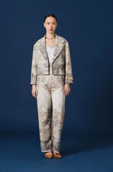 Saco Spencer de corte corto y silueta relajada, con solapas anchas y estampado de paisaje boscoso en tonos beige, gris y marrón. Incluye detalle de etiqueta con logo en la manga izquierda.
