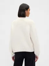 Buzo de punto de algodón con cuello redondo, mangas largas con hombros caídos y puños y ruedo acanalados. Diseño de corte holgado.