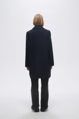 Tapado de corte sastrero en color azul marino, con solapas clásicas, cierre frontal de un botón y bolsillos laterales ocultos.