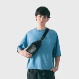 Riñonera rústica de cuero sintético negro con diseño práctico y resistente. Cuenta con tres compartimentos con cierre independiente y correa ajustable.