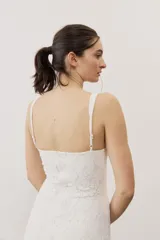 Vestido largo de encaje blanco con tirantes finos y silueta ajustada.