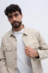 Sobrecamisa de algodón color beige con efecto lavado, bolsillos frontales con solapa y cierre de botones.